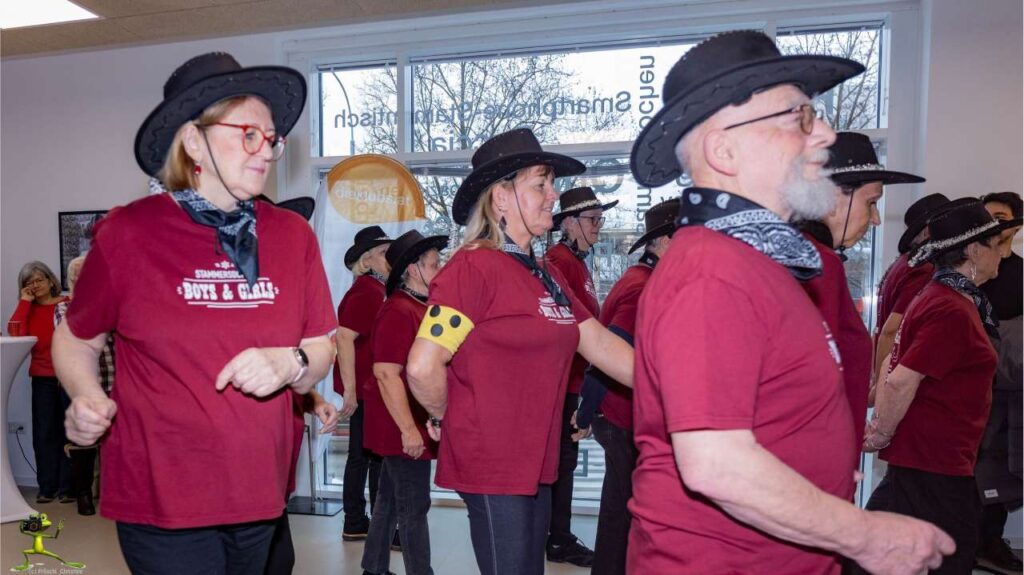 Viele Pensionist:innen im roten T-Shirt tanzen Line Dance