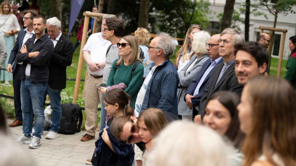 Besucher:innen hören den Reden zu